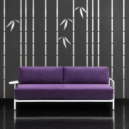 Metallic silver slender bamboo on charcoal wall behind a purple sofa, wide view